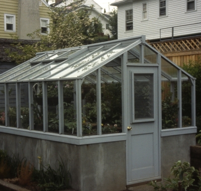 Redwood greenhouse on poured concrete wall