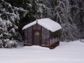 Redwood & glass greenhouse in snow