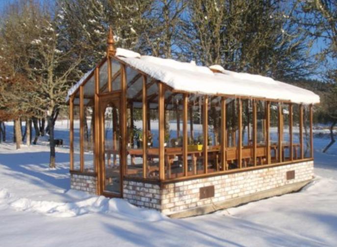 Tall redwood greenhouse in snow