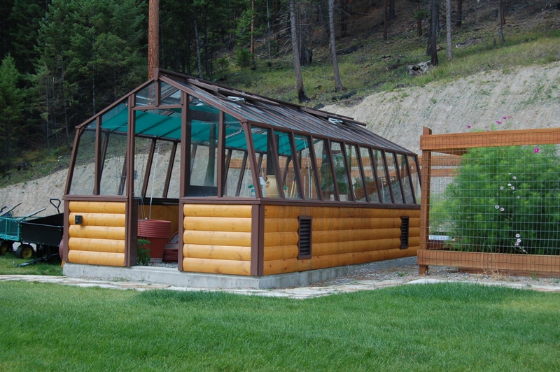 Redwood greenhouse with log base wall