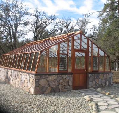 Large home greenhouse on stone base with Jalousie windows