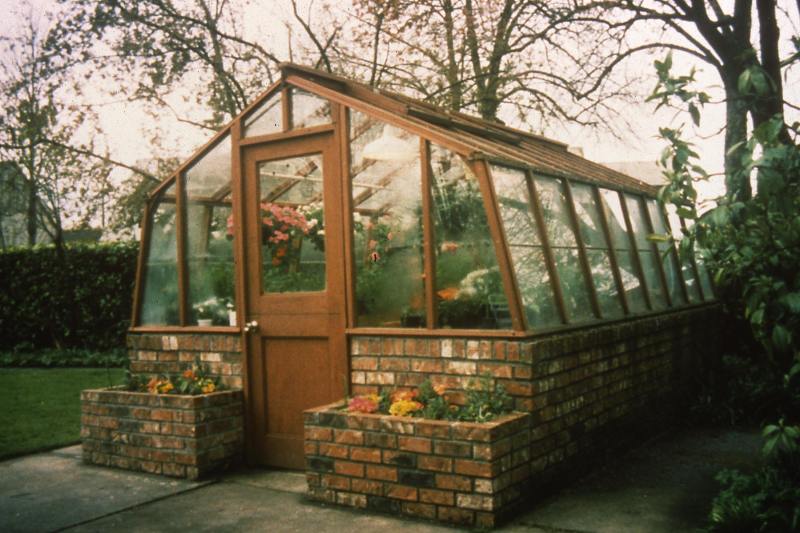Glass greenhouse with brick base wall