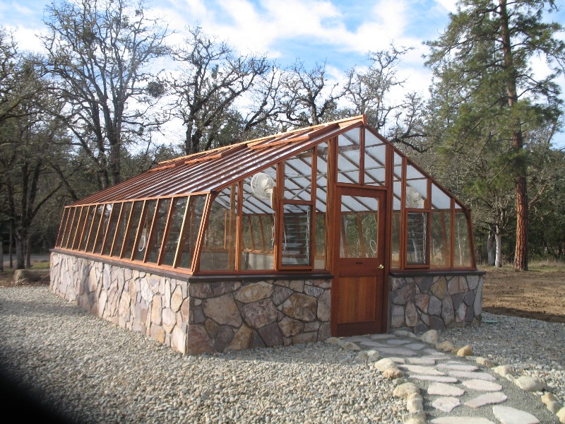 Large home greenhouse on stone base with Jalousie windows