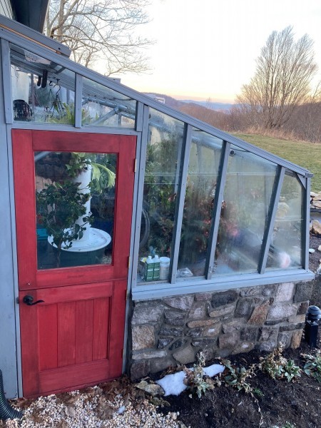 Door end view of 9x12 Tropic Lean-to greenhouse with stone base wall and Dutch door