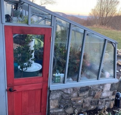 Door end view of 9x12 Tropic Lean-to greenhouse with stone base wall and Dutch door