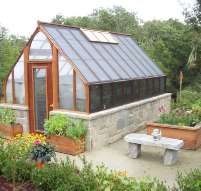 Tudor style home greenhouse with masonry base