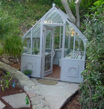 Small Tudor greenhouse that is stained gray