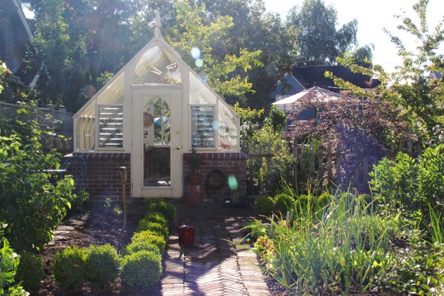 Tudor style garden greenhouse with brick base wall