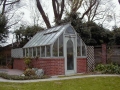 Home redwood greenhouse on brick base