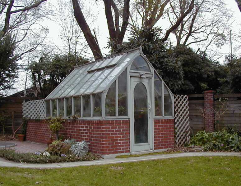 Home redwood greenhouse on brick base